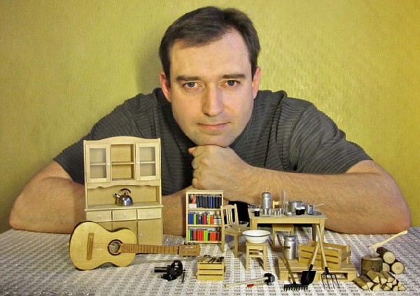 Dmitry Okhotsky poses with miniature wonders that took him months to create from broken gadgets and trash